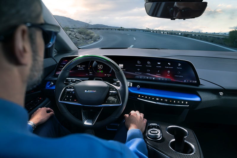 Front View of the 2026 OPTIQ-V Driving Through the Dusk Utilizing its Headlights | Cadillac Mount Kisco in Mount Kisco NY